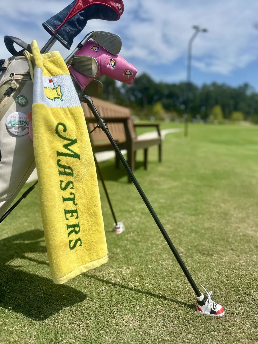 A customer's golf bag on the course wearing red, black and white Shoobies
