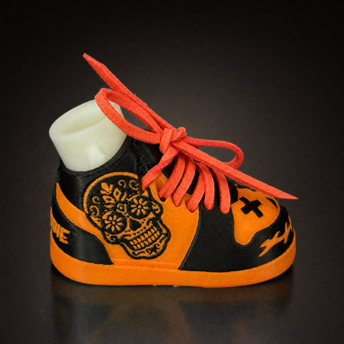 Sugar Skull Shoe Pair, side view. Orange and black shoe shell with a sugar skull graphic and orange laces.